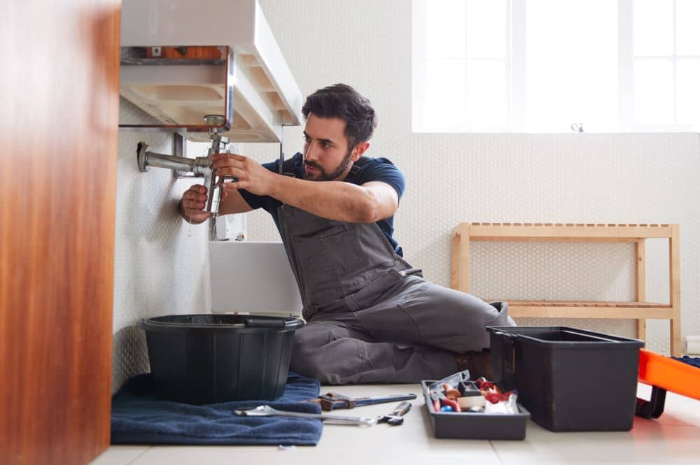 Plumber fixing leaking sink.