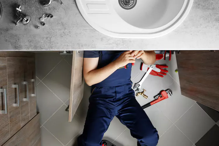 Plumber underneath a sink