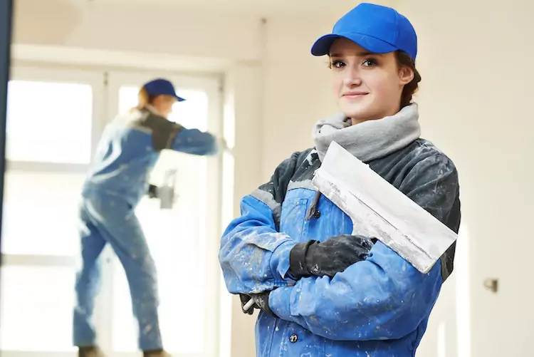 Female plasterer with public liability coverage holding her tools