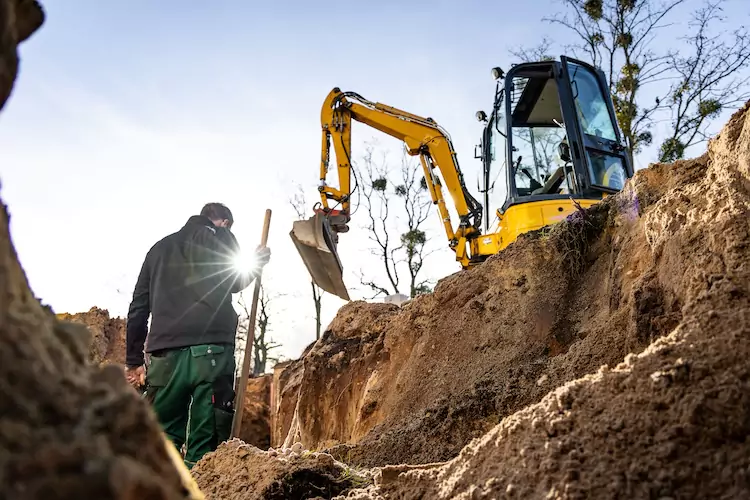 Earthmover with public liability insurance holding a shovel