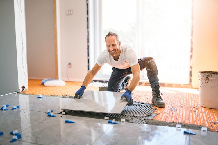 Tiler with tilers insurance holding a ceramic tile