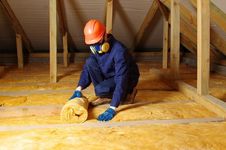 Worker insulate the attic with mineral wool