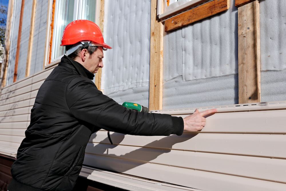 Insured cladding installer installing cladding