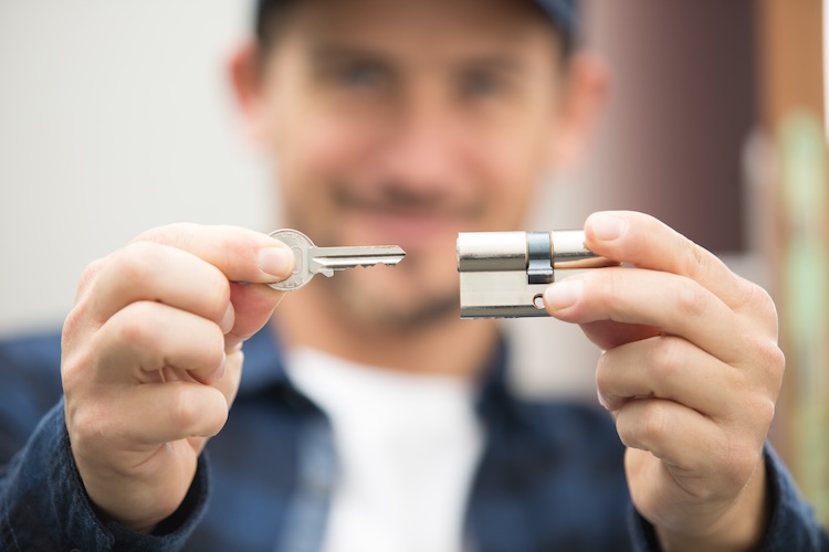 Locksmith with public liability pointing key into a lock