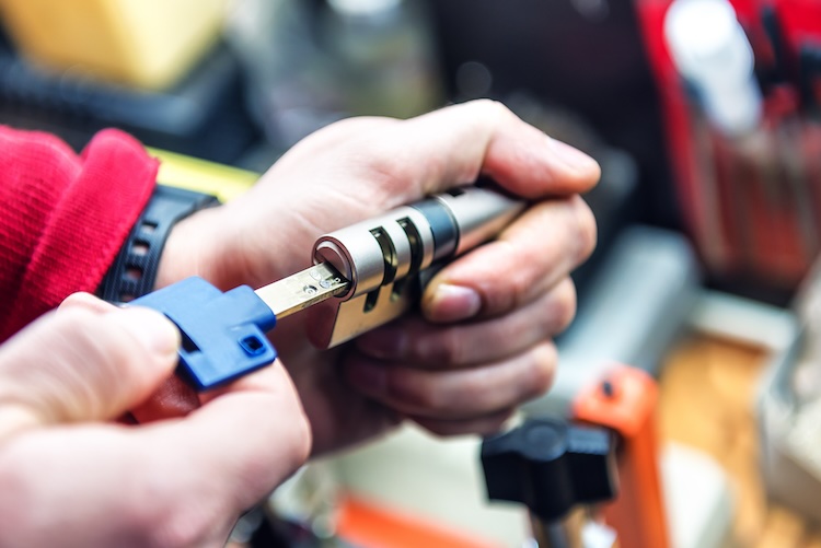 Locksmith with public liability is testing door lock cylinder with key