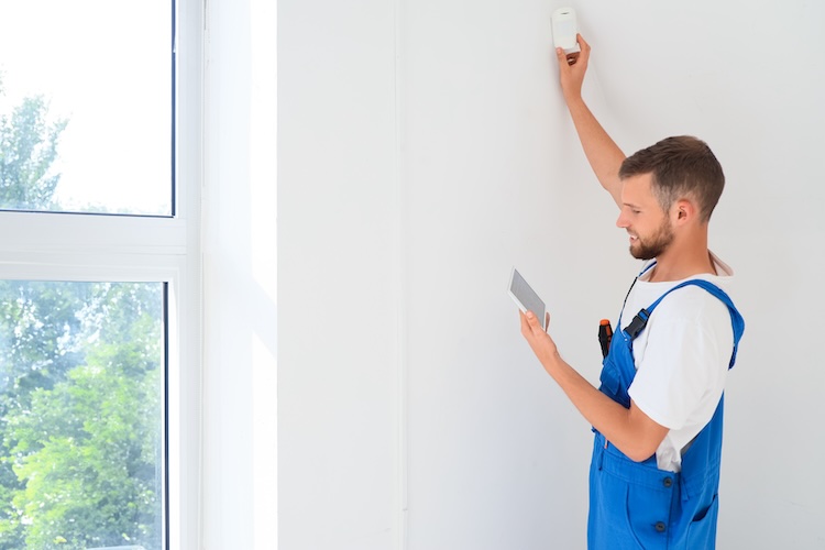 Alarm installer installing a motion sensor