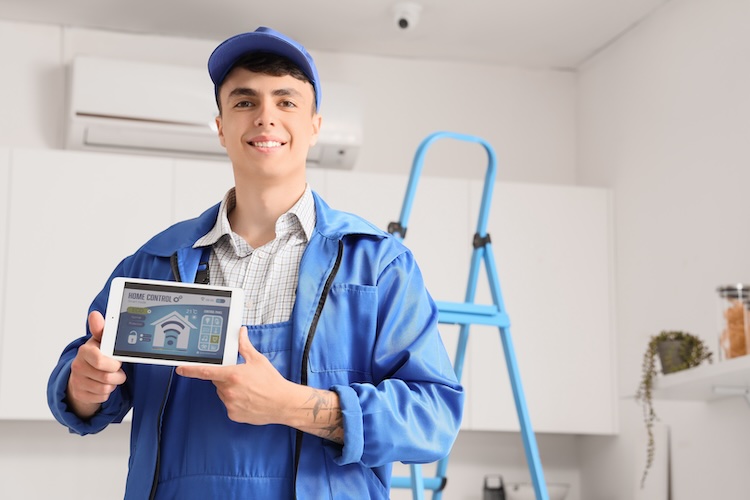 Alarm installer showing a tablet with a home security system app