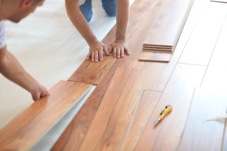 Insured flooring contractors installing laminate flooring in new home indoor